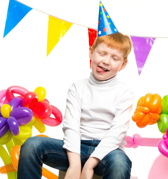 Grappige kleine roodharige jongen onder verjaardagsballons — Stockfoto