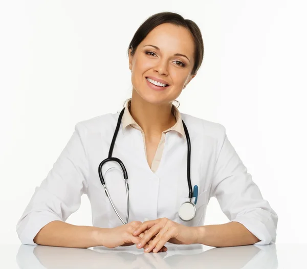 Unga positiva brunett läkare kvinnan bakom tabell — Stockfoto