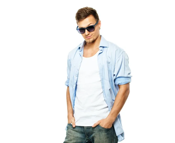Homme élégant en chemise bleue et jeans portant des lunettes de soleil isolées sur blanc — Photo