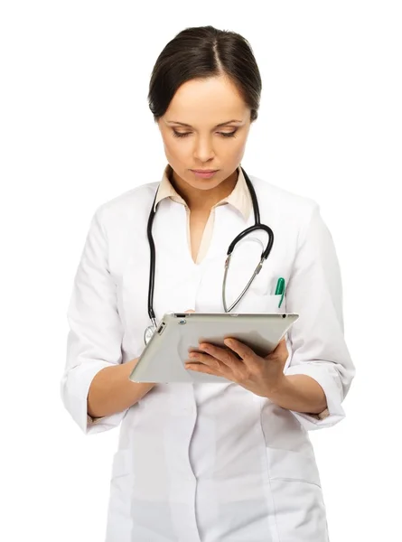Junge brünette Ärztin macht sich Notizen auf Tablet-PC — Stockfoto