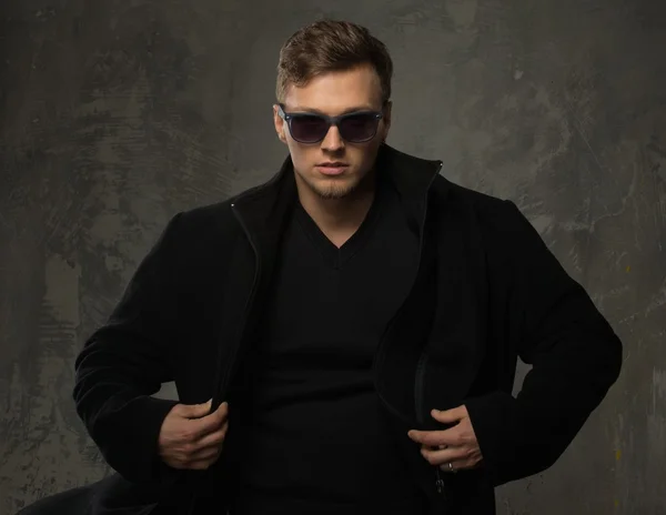 Jovem elegante em casaco preto e óculos de sol — Fotografia de Stock