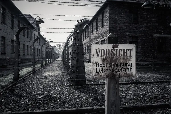 Cerca elétrica e aviso no antigo campo de concentração nazista Auschwitz I, Polônia — Fotografia de Stock
