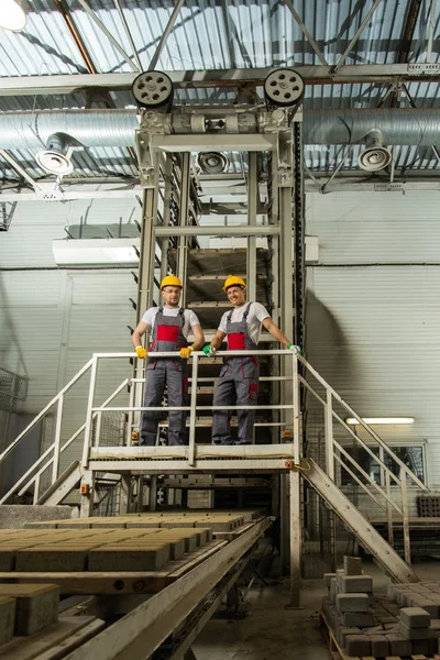 Två män i en säkerhet hattar på en fabrik — Stockfoto