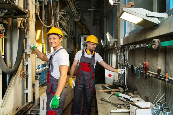 Zwei Arbeiter in Schutzanzügen auf einer Fabrik in der Nähe einer Maschine — Stockfoto