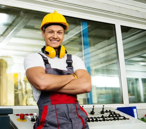 Trabalhador feliz usando chapéu de segurança em uma sala de controle de fábrica — Fotografia de Stock