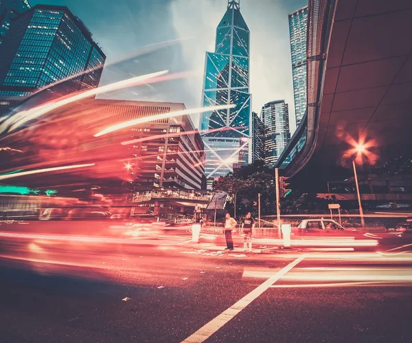 Carros em movimento rápido à noite na cidade moderna — Fotografia de Stock