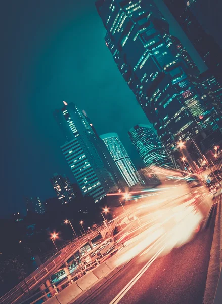Fast moving cars at night in modern city — Stock Photo, Image