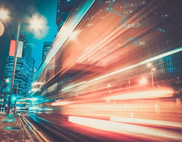 Fast moving cars at night in modern city — Stock Photo, Image