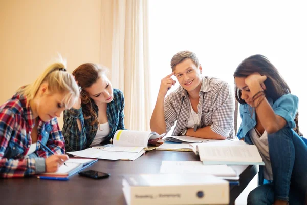 Multi-ethnische Gruppe von Studenten bereitet sich auf Prüfungen im Haus hinter dem Tisch vor — Stockfoto