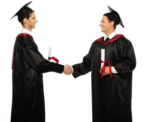 Alegres jóvenes estudiantes graduados estrechando las manos aislados en blanco — Foto de Stock