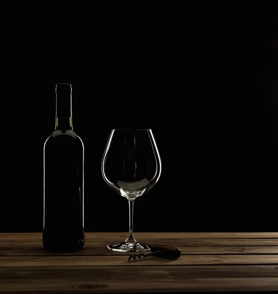 Botella, vidrio y sacacorchos en una mesa de madera —  Fotos de Stock