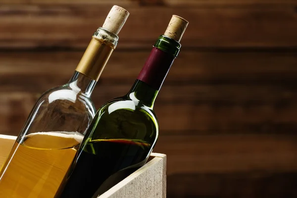 Botella de vino tinto y blanco en caja de madera — Foto de Stock