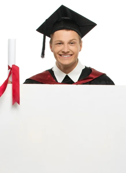 Cheerful young graduated student man with blank notice board — Stock Photo, Image