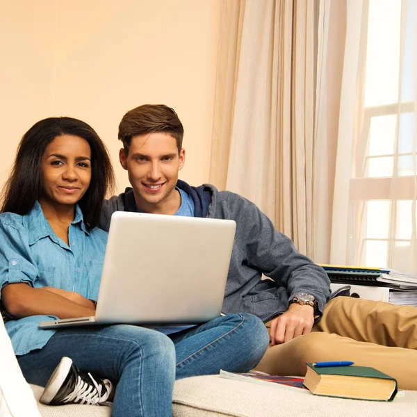 Jeunes étudiants multi-ethniques couple se préparant pour les examens à l'intérieur de la maison — Photo