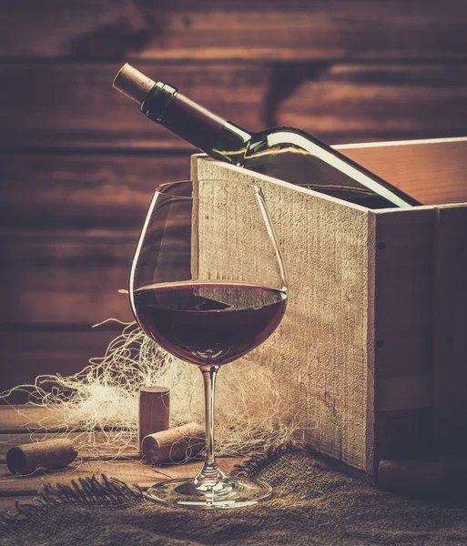 Bottle and glass of red wine on a wooden table — Stock Photo, Image