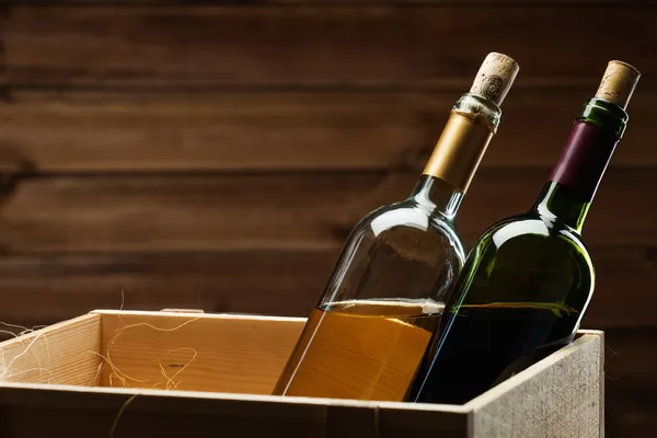 Garrafa de vinho tinto e branco em caixa de madeira — Fotografia de Stock