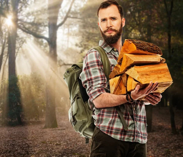 Handsome traveler with backpack in autumnal forest — Stock Photo, Image