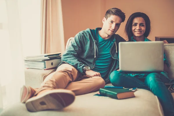 Unga multi etniska studenter par förbereder sig för tentor i heminredning — Stockfoto