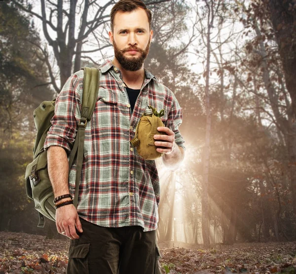 Beau voyageur avec sac à dos et de la fiole dans la forêt automnale — Φωτογραφία Αρχείου