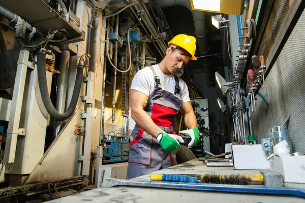 Trabajador en sombrero de seguridad en sala de máquinas en una fábrica —  Fotos de Stock