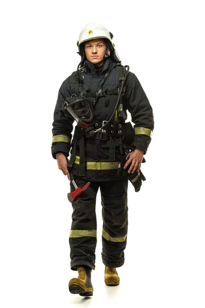 Young firefighter with helmet and axe isolated on white — Stock Photo, Image