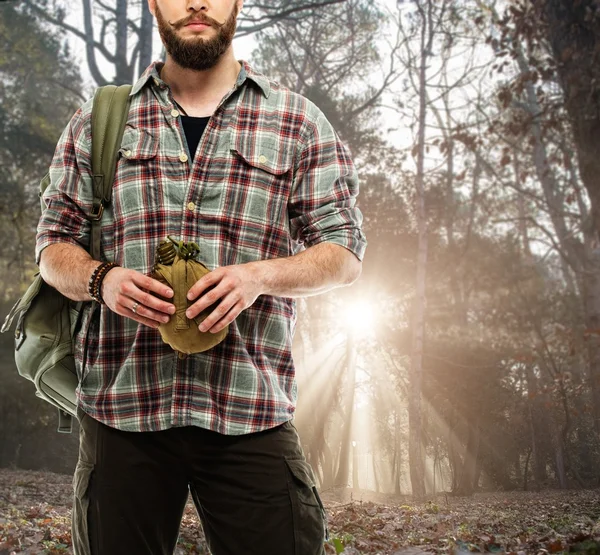 Fešák cestovní batoh a baňka se umístí do podzimního lesa — Stock fotografie