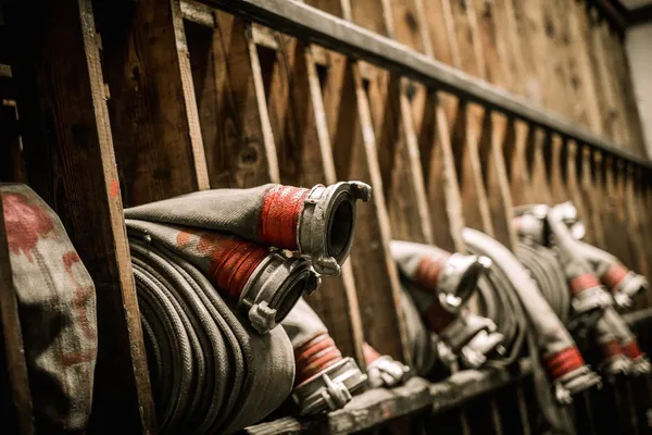 Salle de stockage dans un dépôt de lutte contre l'incendie avec des tuyaux d'eau — Photo