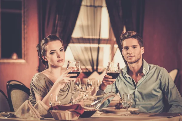 Schönes junges Paar mit Gläsern Wein im Restaurant — Stockfoto