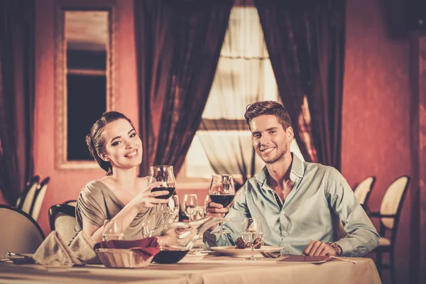 Schönes junges Paar mit Gläsern Wein im Restaurant — Stockfoto