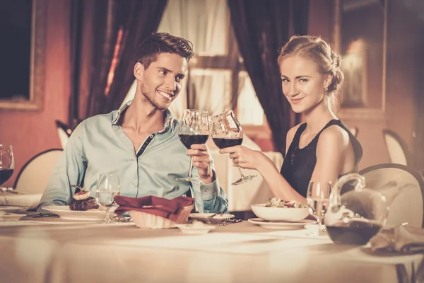 Schönes junges Paar mit Gläsern Wein im Restaurant — Stockfoto