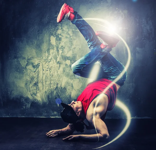 Elegante bailarín de hombre mostrando movimientos de break-dance con vigas mágicas a su alrededor — Foto de Stock