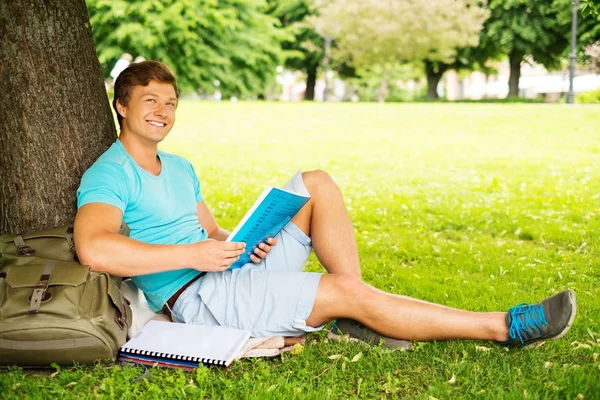 Hombre guapo estudiante en un parque de la ciudad en el día de verano —  Fotos de Stock