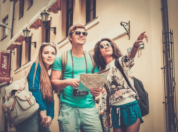 Multi-ethnic friends tourists with map in old city — Stock Photo, Image