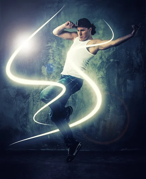 Elegante bailarín de hombre mostrando movimientos de break-dance con vigas mágicas a su alrededor —  Fotos de Stock