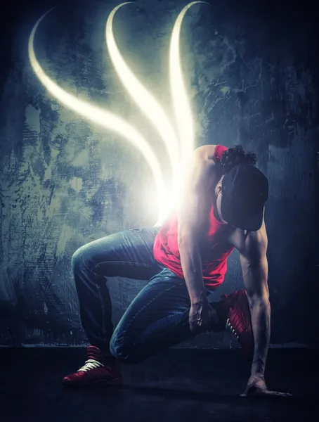 Dançarino homem elegante mostrando break-dançando movimentos com feixes mágicos em torno dele — Fotografia de Stock