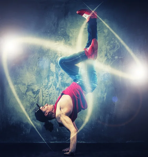 Elegante bailarín de hombre mostrando movimientos de break-dance con vigas mágicas a su alrededor —  Fotos de Stock