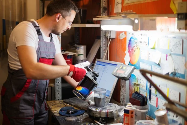 Serviceman mixing paint in a car body workshop — Stock Photo, Image