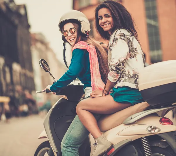 Multi ethnic girls on a scooter in european city — Stock Photo, Image