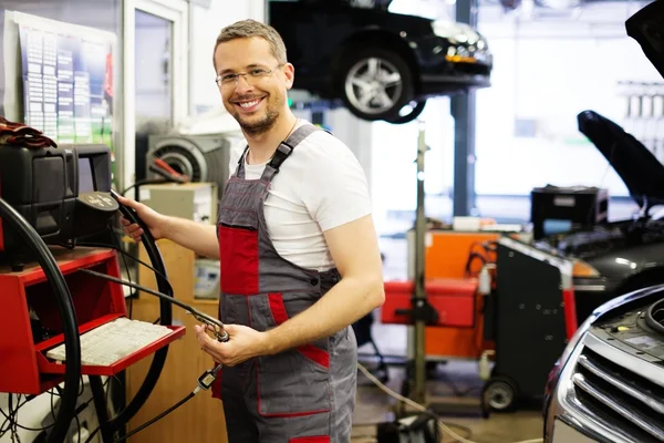 Servicemann mit Co-hc-Diagnosewerkzeug in einer Autowerkstatt — Stockfoto