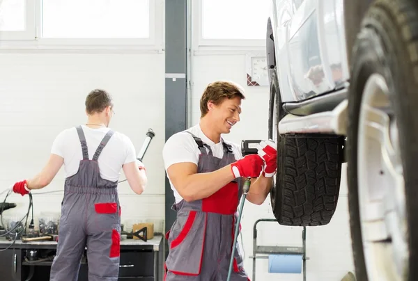 Soltero desenroscar rueda en taller de coches — Foto de Stock