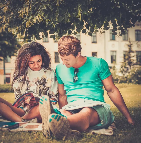 Couple d'étudiants multi-ethniques se préparant aux examens finaux dans un parc de la ville — Photo