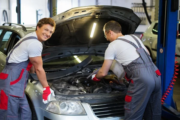 Two mechanics fixing car in a workshop — Stock Photo, Image