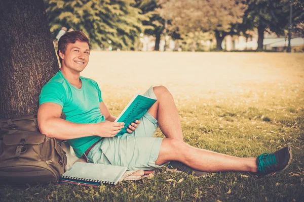 Schöner Mann Student in einem Stadtpark an einem Sommertag — Stockfoto