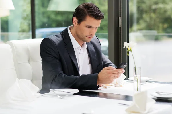 英俊的男人，与餐厅的移动电话 — 图库照片