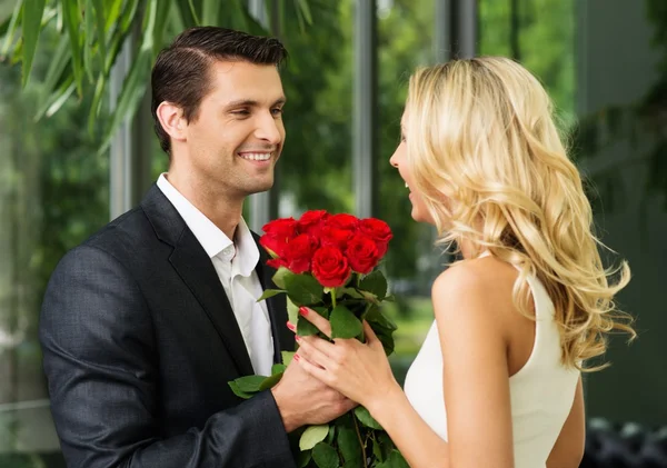 Bel homme avec un tas de rouge sortir ensemble sa dame — Photo