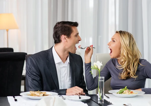 Fröhliches Paar in einem Restaurant mit einem Glas Rotwein — Stockfoto