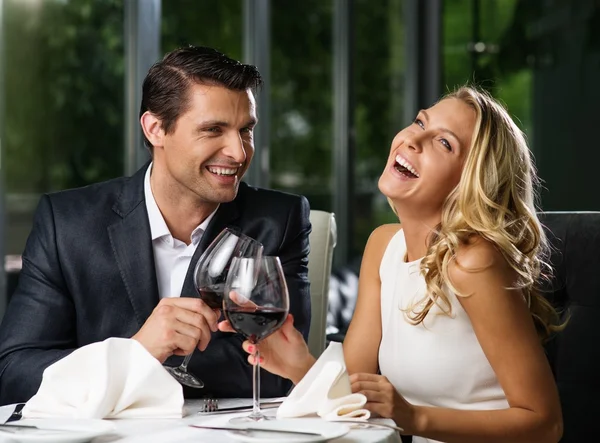 Vrolijke paar in een restaurant met glazen rode wijn — Stockfoto