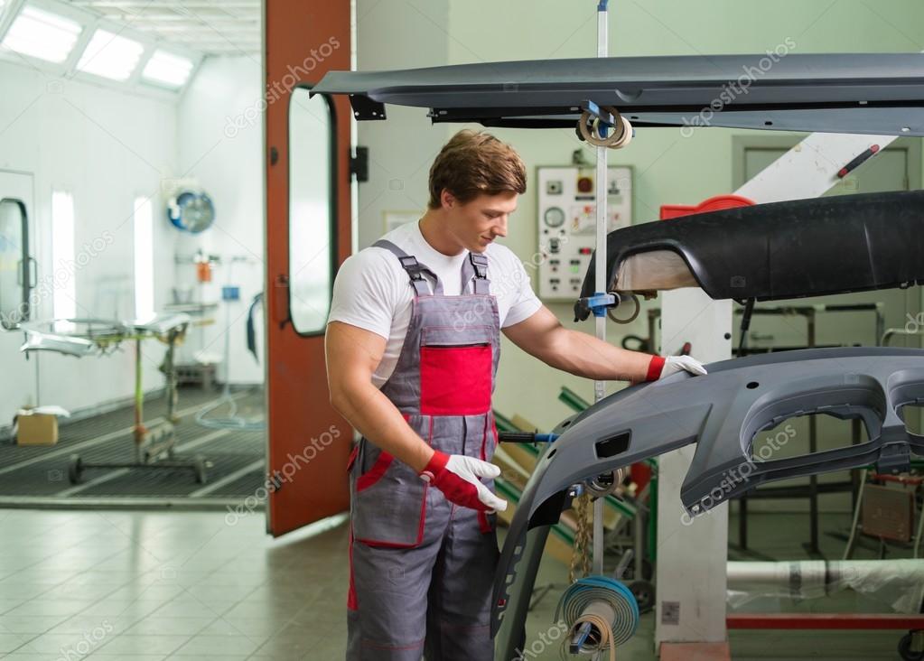 Serviceman with car bodykit ready for painting in a Stock Photo by ©nejron 48591543