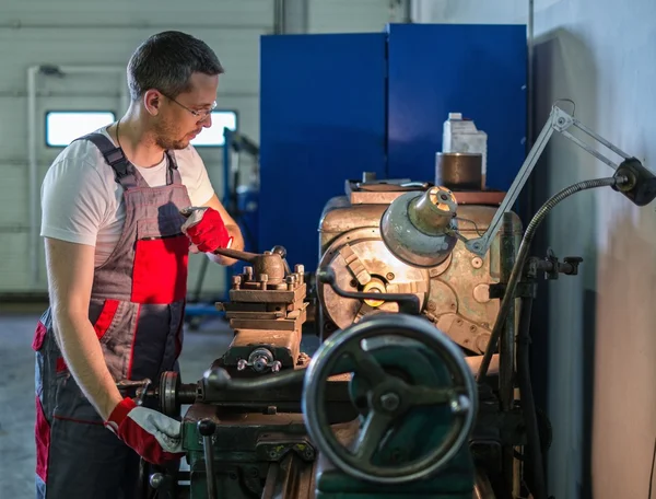 Serviceman working on lathe machine in car workshop — Stock Photo, Image