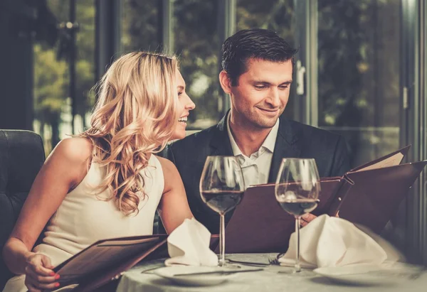Веселая пара с меню в ресторане — стоковое фото